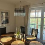 Raum mit gemütlicher Sitzecke und 65 Zoll TV Offener Küche mit Tresen und Kochinsel. Essecke mit 6 Plätzen. Blick auf die Felder. und d...