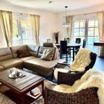 Raum mit gemütlicher Sitzecke und 65 Zoll TV Offener Küche mit Tresen und Kochinsel. Essecke mit 6 Plätzen. Blick auf die Felder. und d...