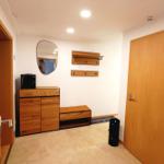 Eingangsbereich mit Holzmöbeln, Spiegel und Hakenwand.