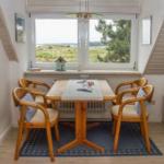 Esszimmer mit Holztisch, vier Stühlen und Blick auf die Landschaft.