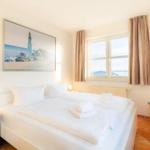 Schlafzimmer mit Doppelbett, Fenster und Wandbild