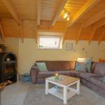 Wohnzimmer mit Sofa, Kamin und Holzdecke.