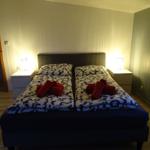 Schlafzimmer mit Doppelbett, zwei Nachttischen und Lampen.