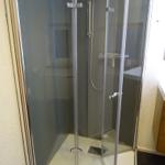 Duschkabine mit Glaswänden und Handbrause