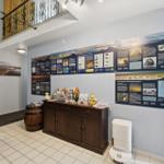 Wohnung mit Informationswänden über Nationalpark Wattenmeer und Holzgeländer im Obergeschoss.