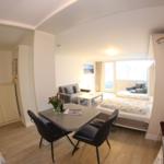 Wohnung mit Schlafzimmer, Essbereich und Küche. Fenster mit Blick nach draußen.