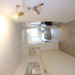 Schlafzimmer mit Doppelbett, Holzwand und Deckenleuchte