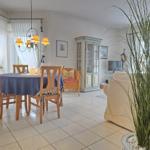 Dining area with table and chairs, living area with sofa and cabinet.