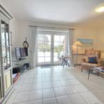 Living room with sliding glass doors, TV, and seating.