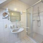 Bathroom with shower, sink, and mirror.