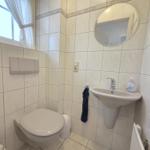 Bathroom with toilet, sink, and mirror