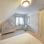 Bedroom with crib, bed, and wardrobe