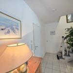 Entrance area with staircase, plant, and lamp on wooden console