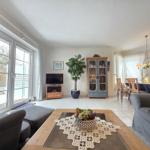 Living and dining area with sofa, coffee table, and TV.