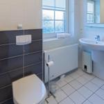Badezimmer mit Toilette, Waschbecken und Fenster