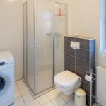 Badezimmer mit Dusche, Toilette und Waschmaschine