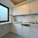 Küche mit Fenster, Spüle, Herd und Waschmaschine.