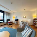 Wohn- und Essbereich mit Sofa, Esstisch und Fernseher.