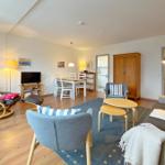 Wohnzimmer mit Essbereich, Sofa, Sessel und Holzboden.