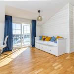 Zimmer mit Bett, Holzboden und Blick auf Wasser