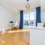 Schlafzimmer mit Fenster, Schreibtisch und Kaminrohr
