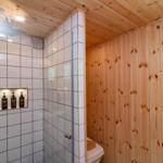 Bad mit Dusche, Toilette und Holzwandverkleidung
