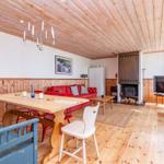 Wohn- und Essbereich mit Holzdecke, Kamin und TV. Holzfußboden und rustikale Möbel.