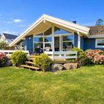 Blue house with terrace and garden. Visible: wooden steps, flowers, and garden furniture.
