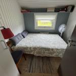 Bedroom with bed, window, chair, and fan.