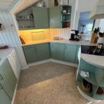 Kitchen with green cabinets, countertop, and stovetop.
