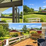Deck with view of lawn and lake. Wooden floor, garden furniture, and flowers.