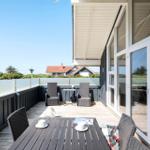 Terrasse mit Tisch, Stühlen und Blick auf Häuser.