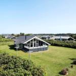 Modernes Ferienhaus mit großem Garten und Blick auf den Strand.
