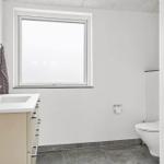 Badezimmer mit Waschbecken, Toilette und Fenster
