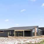 Moderne Villa mit Glasfassade und Terrasse im Freien.