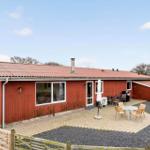 Red house with patio, grill, and outdoor seating area.