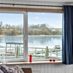 Through the window, a frozen lake with a wooden bridge and trees is visible.