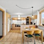 Kitchen with dining area, wooden furniture, and window. Appliances and decor visible.
