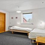 Two beds, window, wooden doors, and gray carpet in a bedroom.