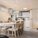 Küche und Essbereich mit Holzwänden und -decke. Tisch mit Stühlen und Küchenschränke.