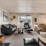 Wohnzimmer mit Sofa, Sessel und Kaminofen. Essbereich mit Tisch und Stühlen.