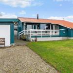 Ein Haus mit Terrasse, grünem Garten und Holzbank vor Garage.