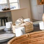 Tisch mit Tellern, Tassen und Brot im Essbereich.