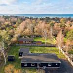 Schwarzes Haus mit Garten und Blick auf Meer und Wald.