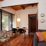 Living and dining area with wooden floor, sofa, chair, and table.