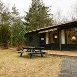 Wooden house with terrace and picnic table in the woods