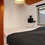 Bedroom with bed, window, and wooden ceiling.