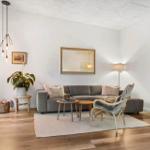 Living room with gray sofa, wooden furniture, and plant.