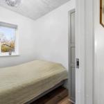 Bedroom with bed, window, and mirror on the wall.