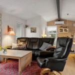 Wohnzimmer mit Ledersofa, Essbereich und Küche im Hintergrund.